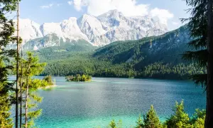 Türkisblaue See mit Inseln, umgeben von dichten Wäldern und majestätischen Bergen. Ein wahres Naturwunder Deutschlands.