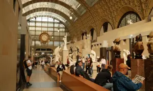 Besucher bestaunen Skulpturen und die große Uhr im **Museum** d'Orsay.