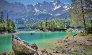 Türkises Wasser und schneebedeckte Berge, ein Kajakfahrer auf dem See – eine idyllische Szene, seen in Deutschland.