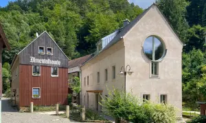 Almentalbaude im Nationalpark Refugium Schmilka, umgeben von üppigem Grün.