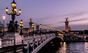 Pont Alexandre III in Paris am Wochenende, beleuchtet bei Dämmerung.