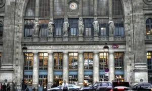 Prachtvolle Fassade des **Paris Nord Bahnhof** mit Statuen und einer Uhr. Autos und Menschen beleben den Vorplatz.