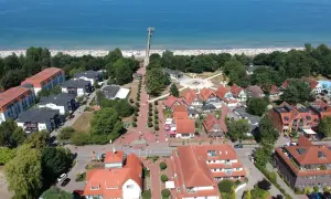 Luftaufnahme von Boltenhagen mit Strand, Promenade und roten Dächern. Hier finden sich viele Geheimtipps für einen entspannten Urlaub an der Ostsee.