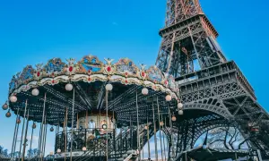 Ein festlich beleuchteter Karussell dreht sich vor dem Eiffelturm am Trocadéro in Paris.