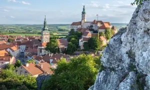 Malerische Stadtansicht von Mikulov, einem der schönsten orte tschechien, mit Schloss und Kirchturm vor grüner Hügellandschaft.