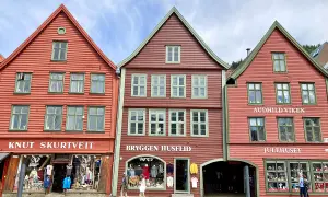 Bunte Holzhäuser in der bergen altstadt, mit Geschäften und Touristen.