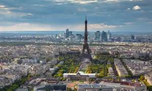 Paris in 2 Tagen: Eiffelturm ragt über die Stadt, umgeben von grünen Parks und Haussmann-Gebäuden. Im Hintergrund moderne Hochhäuser.