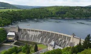 Stausee mit imposanter Staumauer, umgeben von grünen Wäldern. Ein tolles Ziel für Ausflugsziele Hessen, mit Booten auf dem Wasser.