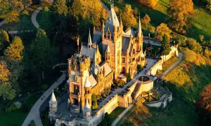 Märchenschloss im Abendlicht, ein tolles Ziel für Ausflugsziele Bonn. Umgeben von bunten Bäumen und grünen Hügeln.