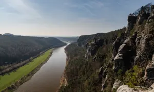 Blick von den Felsen auf die Elbe und die umliegenden Wälder. Eine perfekte Kulisse für eine **Rauenstein Wanderung**.