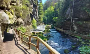 Holzstege schlängeln sich durch eine Schlucht mit Kaskaden. Ein perfekter Ort zum Hrensko wandern.