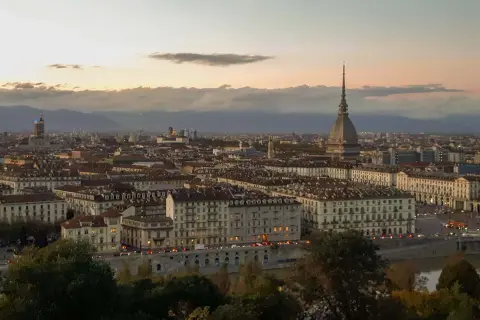 Turin bei Sonnenuntergang, ein versteckter Schatz unter den **italien geheimtipps**. Die Mole Antonelliana ragt über die Stadt.