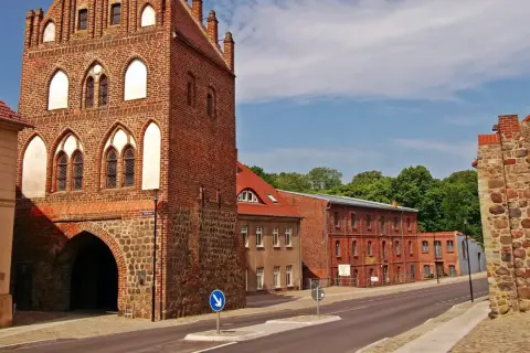 Historisches Stadttor in Templin Altstadt, mit Backstein und Feldsteinmauern. Dahinter rote Backsteingebäude und grüne Bäume.