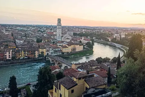 Sonnenuntergang über Verona: malerischer Blick auf die Etsch, die Ponte Pietra und den Torre dei Lamberti. Ein perfekter Ort für Sightseeing in Verona.