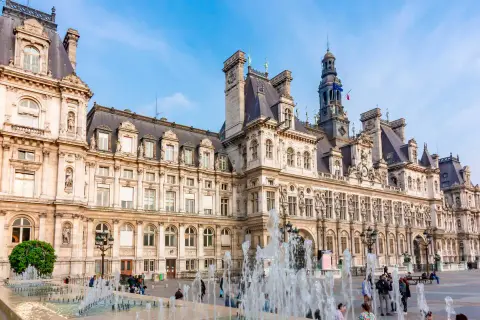 Das Hôtel de Ville in Paris, ein prächtiges Gebäude mit Wasserspielen davor.