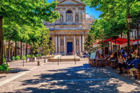 Ein sonniger Tag in Paris, mit Menschen, die in Cafés sitzen. Perfekt für alle unter 26, die Paris kostenlos erleben wollen.