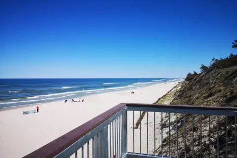 Ein einsamer Strand an der polnischen Ostsee, ein echter Geheimtipp. Weißer Sand, blaues Meer und ein klarer Himmel.