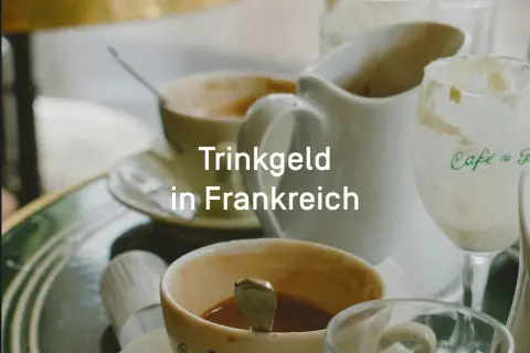 Kaffee und Milch in Paris. Ein Blick auf das Trinkgeld in Frankreich, das oft im Preis inbegriffen ist.