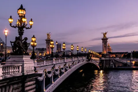 Pont Alexandre III in Paris am Wochenende, beleuchtet bei Dämmerung.