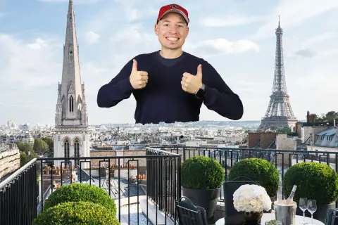 Mann mit Daumen hoch vor Pariser Skyline, mit Eiffelturm und Kirchturm. Ein Traum von der Avenue Montaigne.
