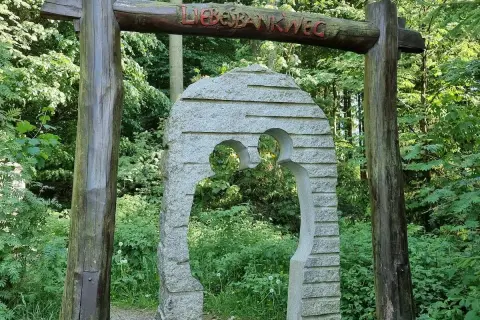 Ein Torbogen aus Holz und Stein markiert den Beginn des Liebesbankweges, einem der schönen **Harz Wanderwege**.