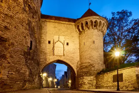 Historisches Stadttor in Tallinn bei Nacht. Ein echter Geheimtipp für Tallinn-Besucher, der zum Erkunden einlädt.