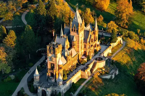 Märchenschloss im Abendlicht, ein tolles Ziel für Ausflugsziele Bonn. Umgeben von bunten Bäumen und grünen Hügeln.