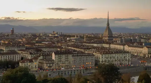 Turin bei Sonnenuntergang, ein versteckter Schatz unter den **italien geheimtipps**. Die Mole Antonelliana ragt über die Stadt.