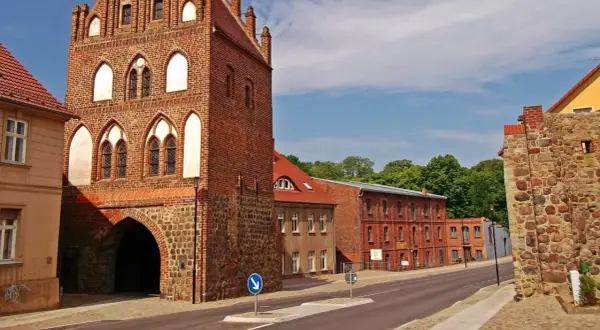 Historisches Stadttor in Templin Altstadt, mit Backstein und Feldsteinmauern. Dahinter rote Backsteingebäude und grüne Bäume.