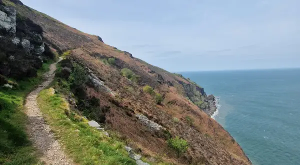 Steiler Küstenpfad mit Blick auf das Meer. Ein Pfad, der zu unvergesslichen south west coast path erfahrungen einlädt.