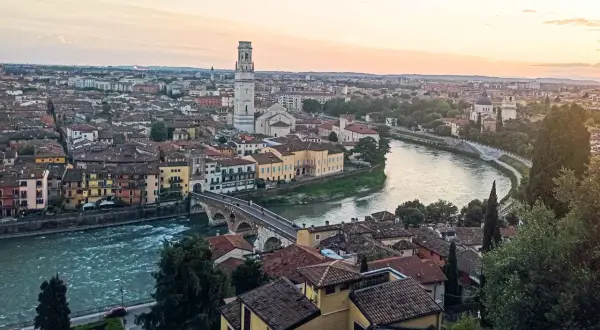 Sonnenuntergang über Verona: malerischer Blick auf die Etsch, die Ponte Pietra und den Torre dei Lamberti. Ein perfekter Ort für Sightseeing in Verona.