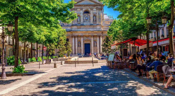 Ein sonniger Tag in Paris, mit Menschen, die in Cafés sitzen. Perfekt für alle unter 26, die Paris kostenlos erleben wollen.