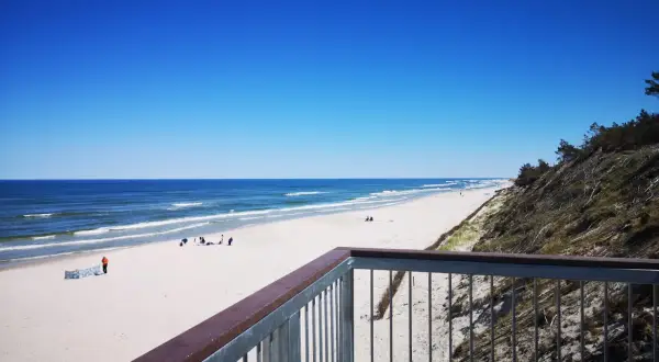 Ein einsamer Strand an der polnischen Ostsee, ein echter Geheimtipp. Weißer Sand, blaues Meer und ein klarer Himmel.