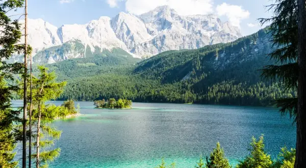 Türkisblaue See mit Inseln, umgeben von dichten Wäldern und majestätischen Bergen. Ein wahres Naturwunder Deutschlands.