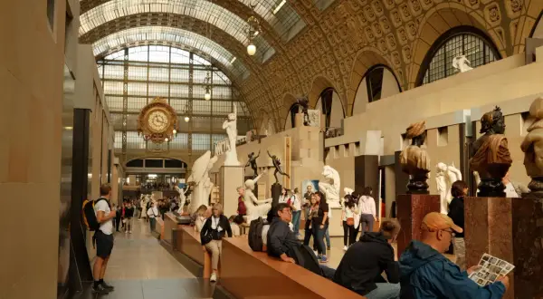 Besucher bestaunen Skulpturen und die große Uhr im **Museum** d'Orsay.