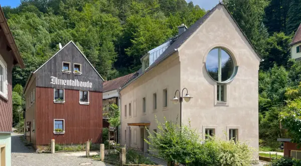 Almentalbaude im Nationalpark Refugium Schmilka, umgeben von üppigem Grün.