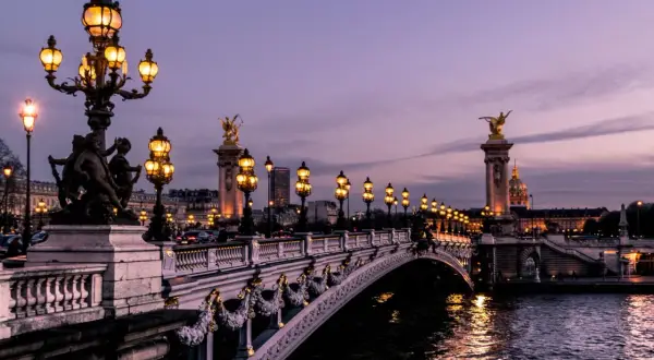 Pont Alexandre III in Paris am Wochenende, beleuchtet bei Dämmerung.