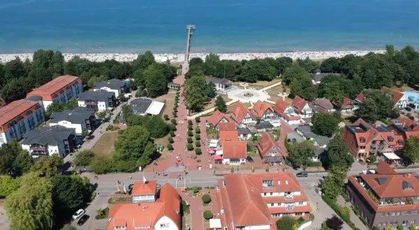 Luftaufnahme von Boltenhagen mit Strand, Promenade und roten Dächern. Hier finden sich viele Geheimtipps für einen entspannten Urlaub an der Ostsee.