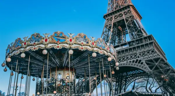 Ein festlich beleuchteter Karussell dreht sich vor dem Eiffelturm am Trocadéro in Paris.