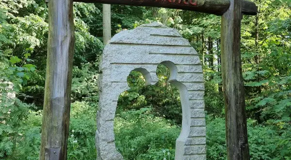 Ein Torbogen aus Holz und Stein markiert den Beginn des Liebesbankweges, einem der schönen **Harz Wanderwege**.