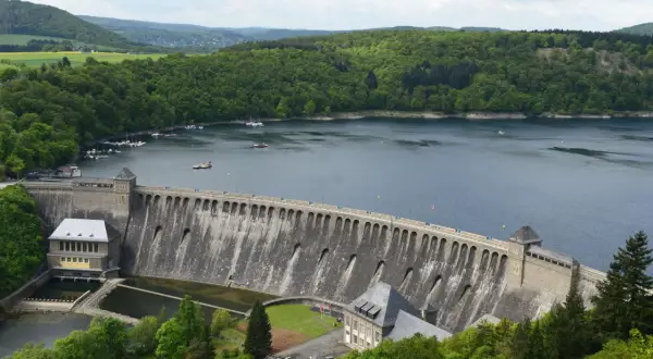 Stausee mit imposanter Staumauer, umgeben von grünen Wäldern. Ein tolles Ziel für Ausflugsziele Hessen, mit Booten auf dem Wasser.