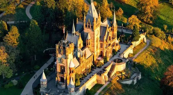 Märchenschloss im Abendlicht, ein tolles Ziel für Ausflugsziele Bonn. Umgeben von bunten Bäumen und grünen Hügeln.
