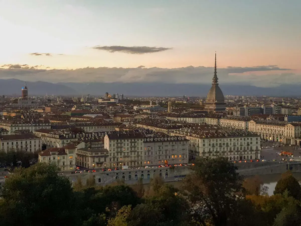 Turin bei Sonnenuntergang, ein versteckter Schatz unter den **italien geheimtipps**. Die Mole Antonelliana ragt über die Stadt.