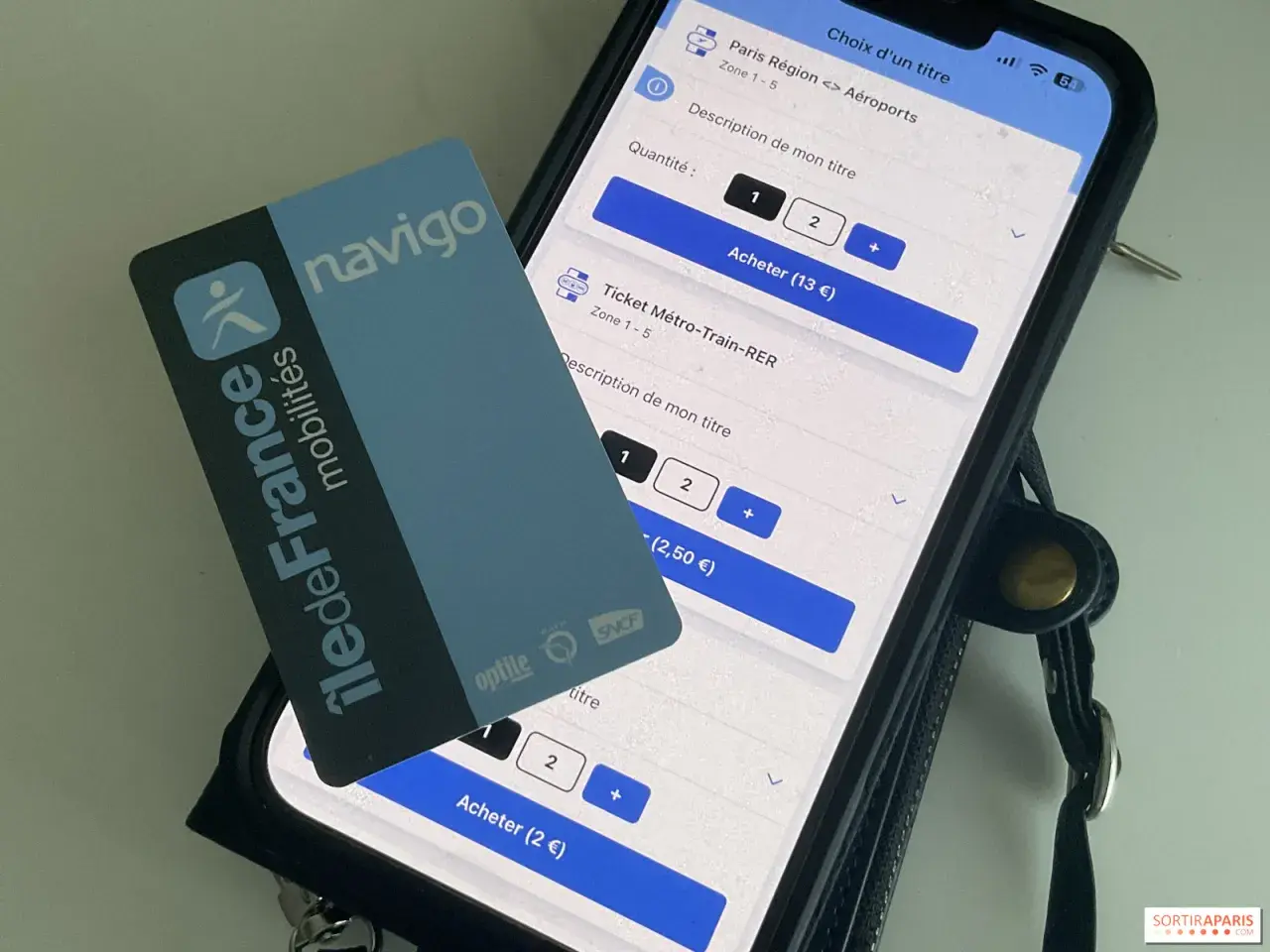 Navigo-Karte und Smartphone zeigen Optionen für den Pariser Nahverkehr.