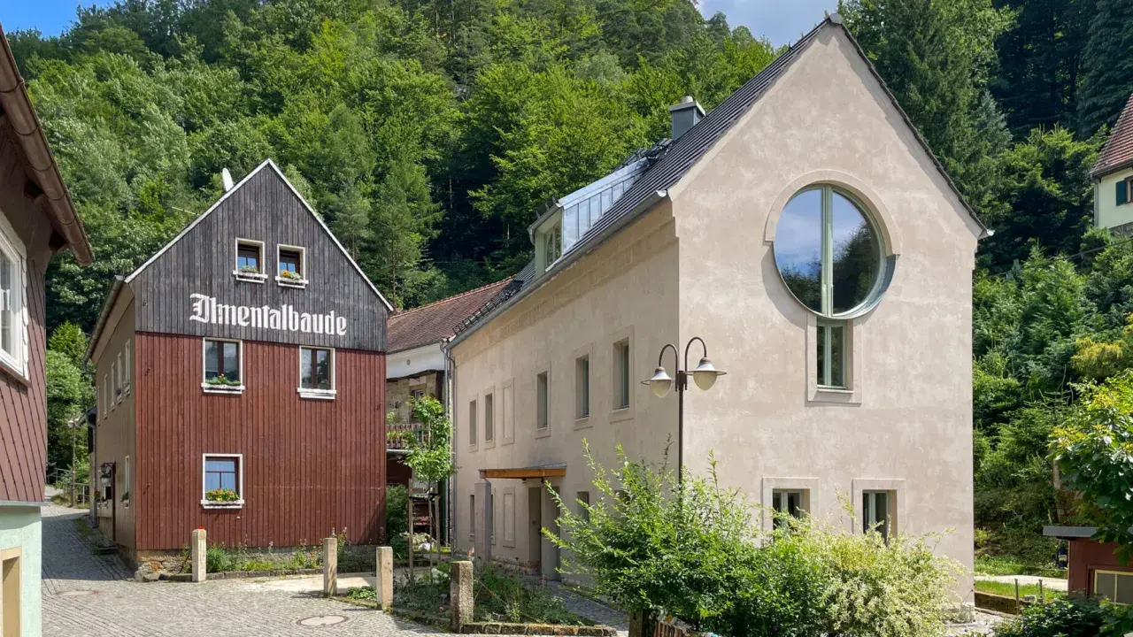 Almentalbaude im Nationalpark Refugium Schmilka, umgeben von üppigem Grün.
