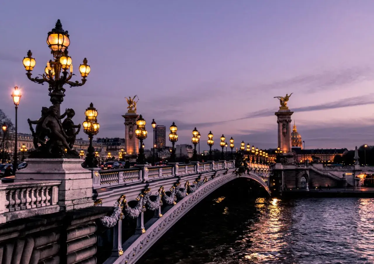 Pont Alexandre III in Paris am Wochenende, beleuchtet bei Dämmerung.