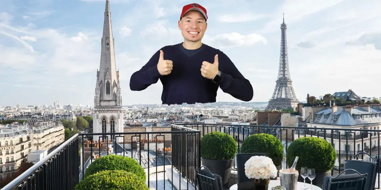 Mann mit Daumen hoch vor Pariser Skyline, mit Eiffelturm und Kirchturm. Ein Traum von der Avenue Montaigne.