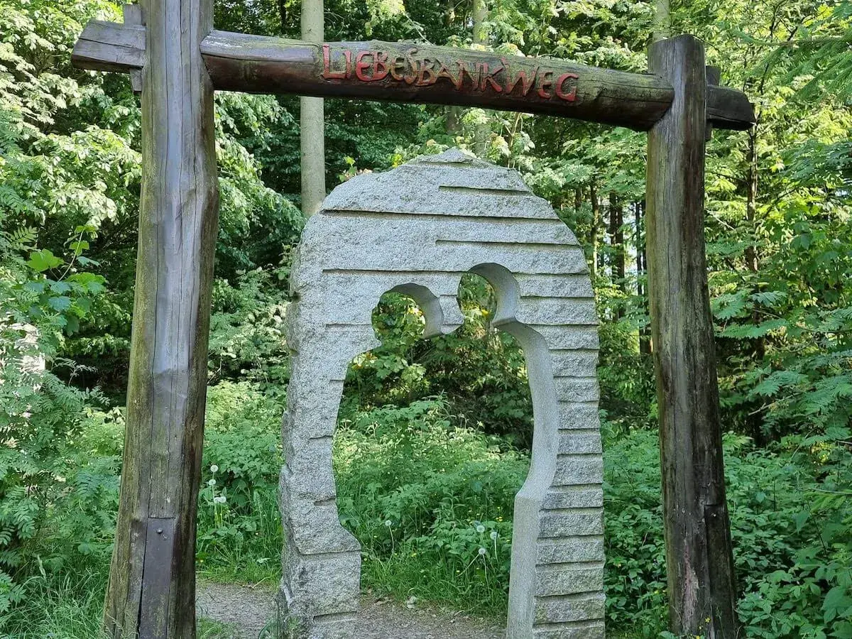 Ein Torbogen aus Holz und Stein markiert den Beginn des Liebesbankweges, einem der schönen **Harz Wanderwege**.