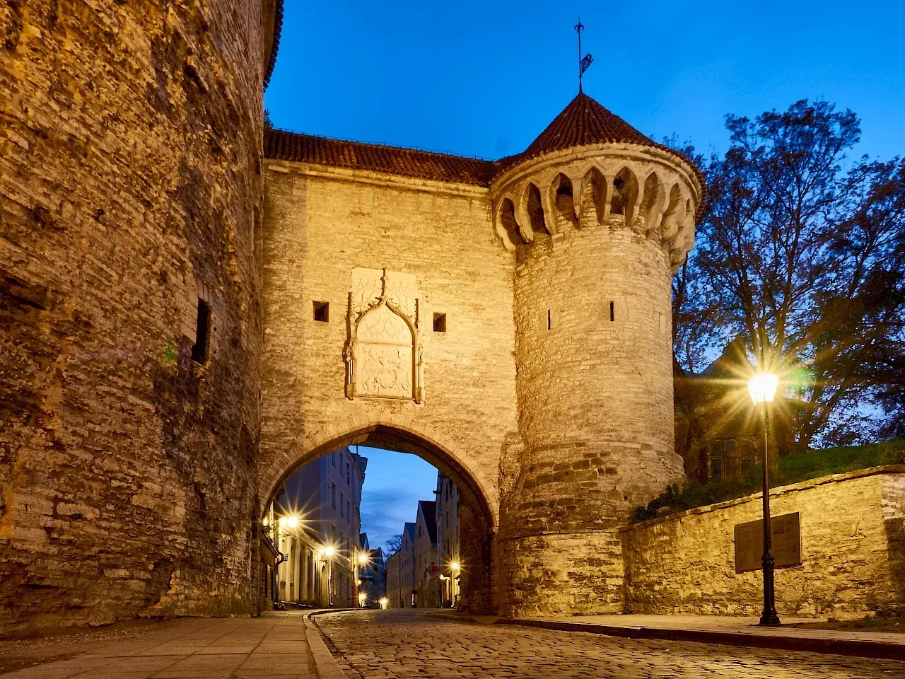 Historisches Stadttor in Tallinn bei Nacht. Ein echter Geheimtipp für Tallinn-Besucher, der zum Erkunden einlädt.
