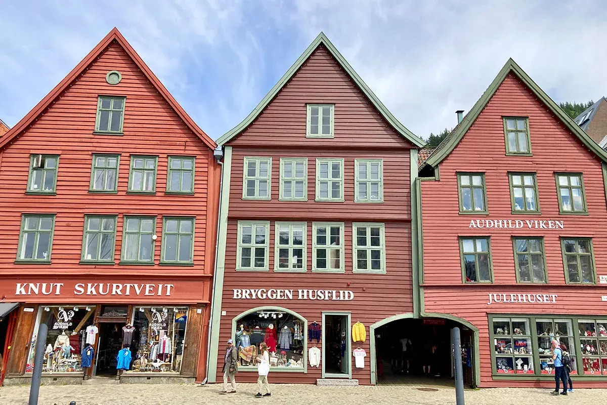 Bunte Holzhäuser in der bergen altstadt, mit Geschäften und Touristen.